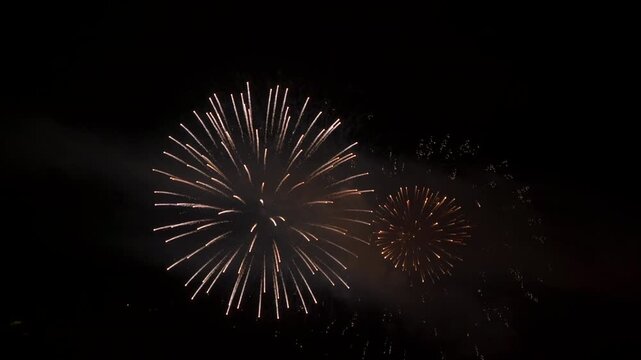 Beautiful fireworks isolated on a night sky in slow motion for an abstract background, ideal for anniversaries, celebrations or New Year's Eve.