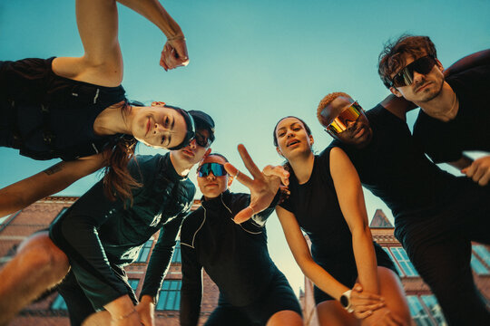 Running friends socializing outdoors in urban run club before group fitness workout