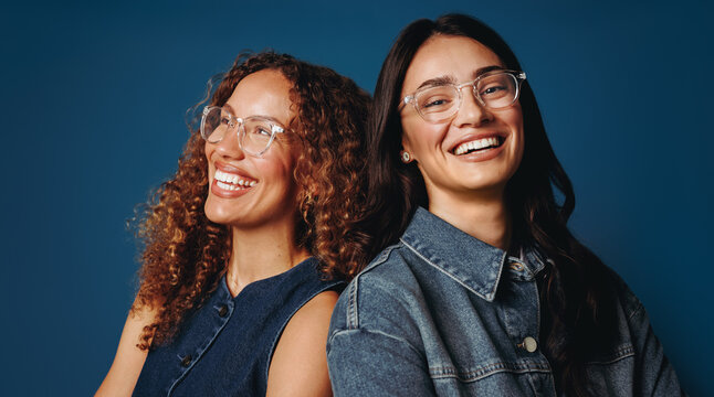 Portrait of diverse women friends smiling confidently in studio setting