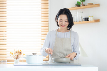 家で料理をするミドルの女性 © dimlight