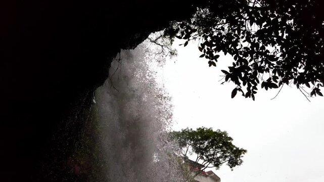 Waterfall cascading over rocky cliff with flowing water mist and lush forest showcasing pristine natural landscape and tropical wilderness in Morelos Mexico