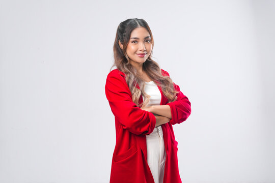 Confident young Asian woman in red jacket is smiling and posing crossing her arms.