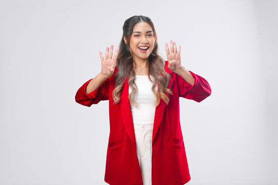 Cheerful Asian young woman is raising her fingers showing number gesture.