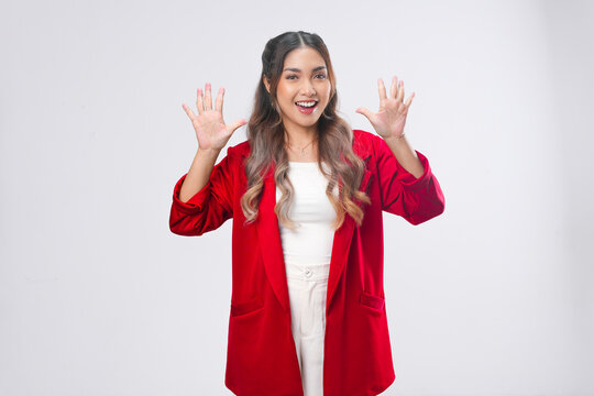 Cheerful Asian young woman is raising her fingers showing number gesture.