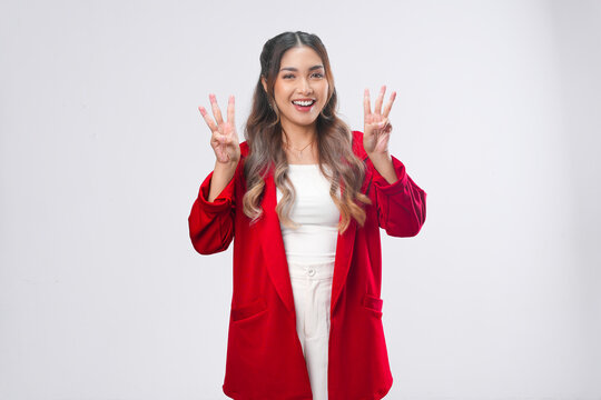 Cheerful Asian young woman is raising her fingers showing number gesture.