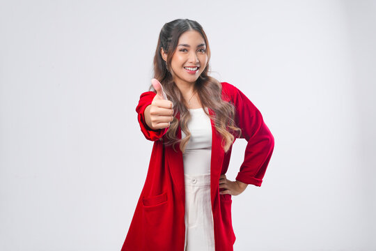 Beautiful young Asian woman in a red jacket showing a thumb up gesture of approval.