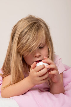 Young Girl Holding a Cup of Assorted Pills and Capsules