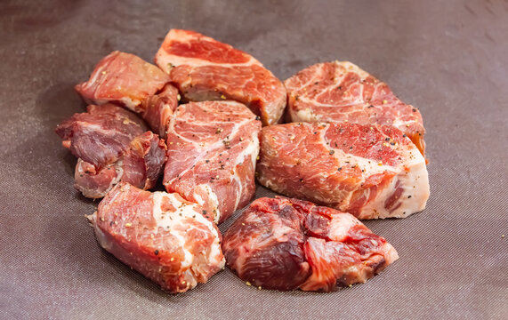 Raw pieces of pork laid for further baking in the oven. In the kitchen