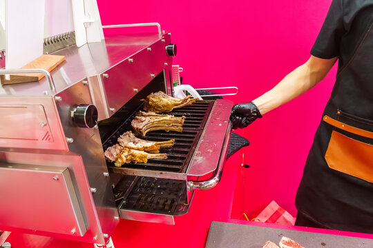 chef grills lamb ribs in a restaurant kitchen