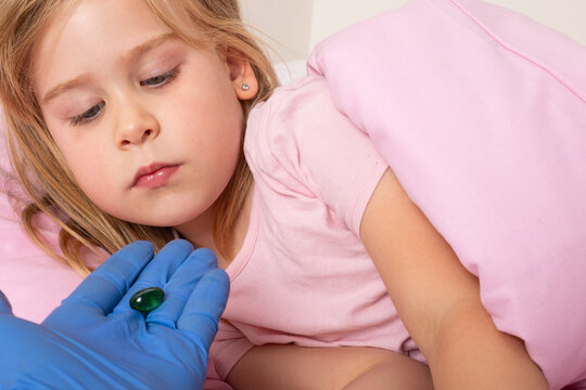 Sick Young Girl Being Offered Medication by a Healthcare Worker