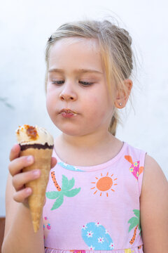 Little Girl Holding Ice Cream Cone and Looking at Camera