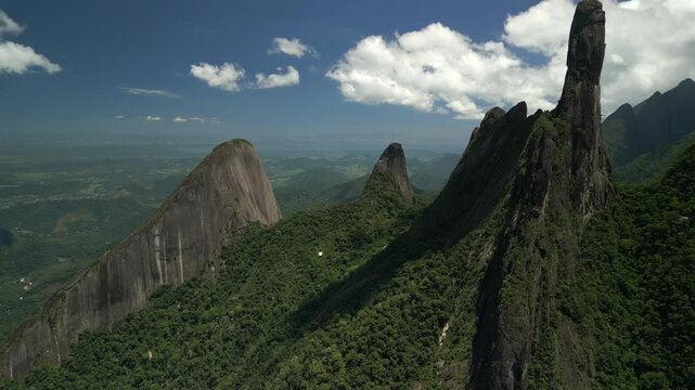 Dedo de Deus rock formation and surrounding valleys, distant horizon, green hills, and Teres&oacute;polis. Forward aerial traverse panning left. Shot on 4K at 25 fps.
