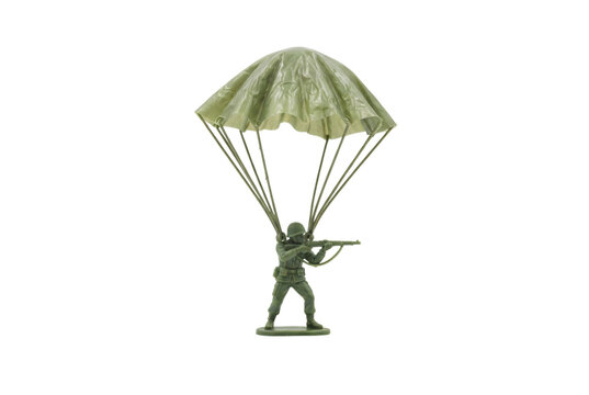 Toy army man descending with a green plastic parachute holding a rifle in shooting posture classic plastic figurine.