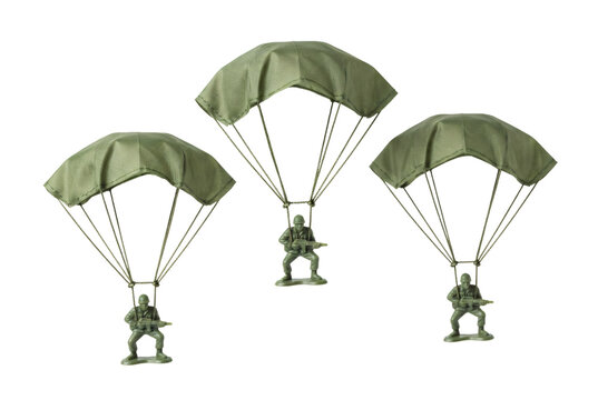 Three green plastic toy paratroopers descending with open parachutes carrying rifles in combat poses.