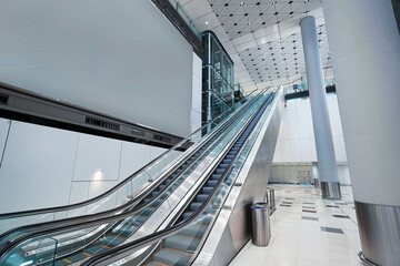 Fototapeta premium Modern Interior Featuring Escalator and Bright Contemporary Artwork in Public Space