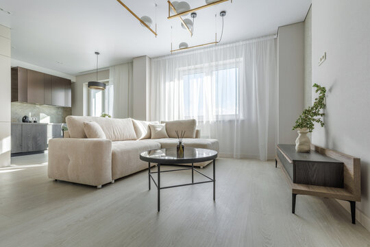 Modern Living Room and Kitchen Interior with Beige Sofa and Coffee Table