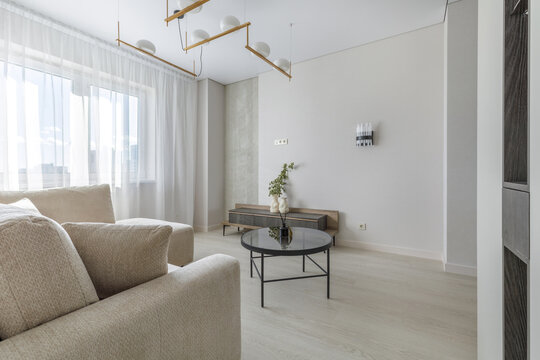Modern Living Room Interior with Round Glass Coffee Table and Chandelier