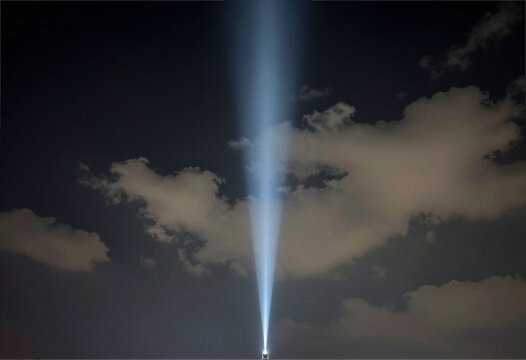 Searchlight beam pointing into the night sky
