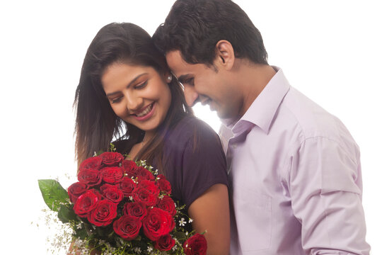 Couple with a bouquet of roses smiling