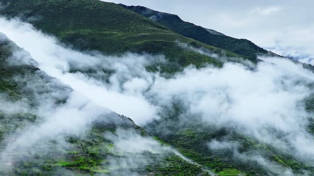 Aerial view of the summer landscape in Shuangqiao Valley Scenic Area of Mount Siguniang, Aba Prefecture, Sichuan, China, with mist-shrouded mountains