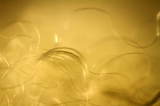 Extreme macro of polyester stable fiber on yellow background. Selective focus, shallow depth of field. Abstract dreamy background