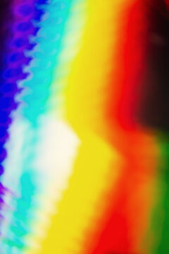 De focused abstract vibrant iridescent holographic rainbow foil background with light leaks. Glitter surface. Abstract blurred rainbow background.