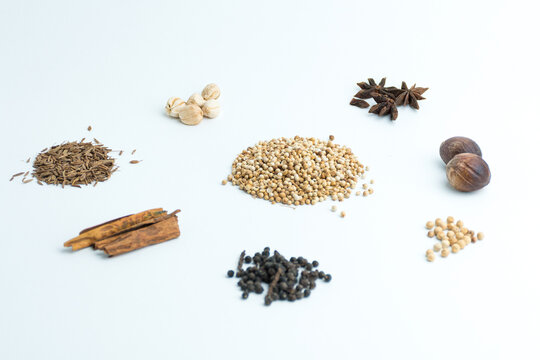 Assortment of dry cooking spices including cinnamon star anise coriander and nutmeg isolated on white