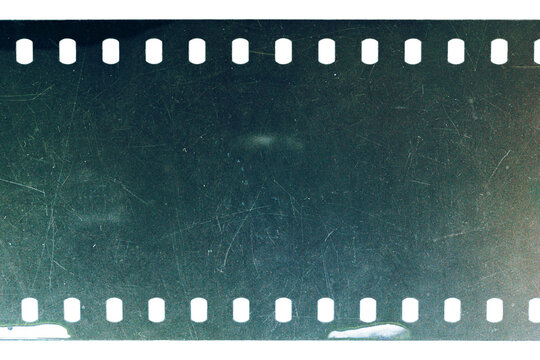 Dusty and grungy 35mm film texture or surface. Perforated scratched camera film isolated on white background.