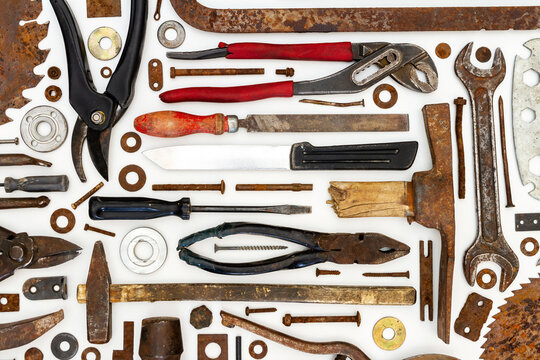 Flat lay of old hand tools on white background. Large collection of various rusty tools and bits arranged on white.