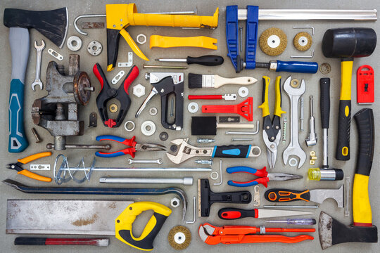 Flat lay of old and new hand tools on concrete background. Large collection of various tools and bits arranged on concrete.