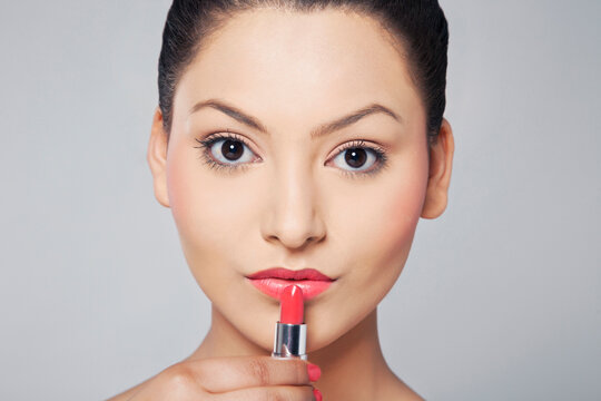 Portrait of woman applying lipstick 