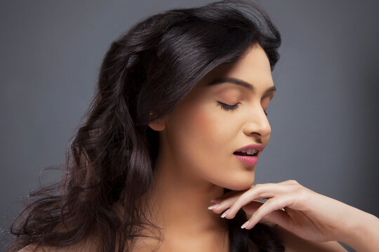 Pretty young female with eyes closed over colored background 