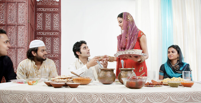 Muslim woman serving food during Id 