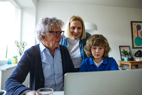 Three family members looking at an object during an everyday family activity at home