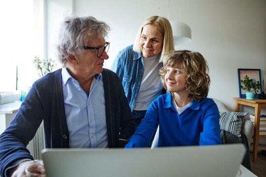 Three family members talking together while sharing a relaxed day at home