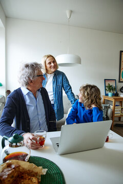 Three family members talking together while spending time together at home