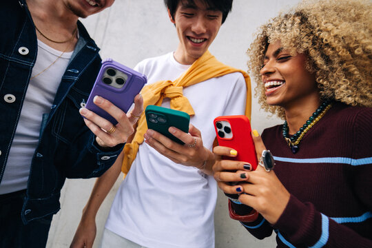 Friends sharing smartphones and social media content together