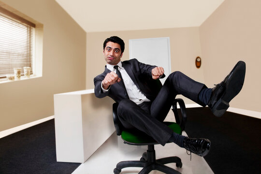 Businessman pretending to ride a motorbike in the office 