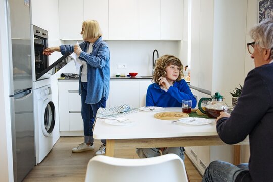 Three family members doing laundry while sharing a relaxed day at home