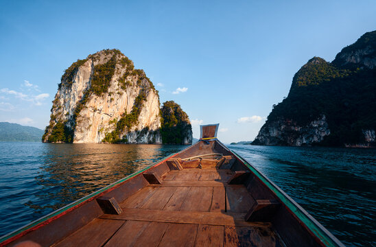 Wooden Boat Approaching Scenic Limestone Cliffs in Tropical Waters