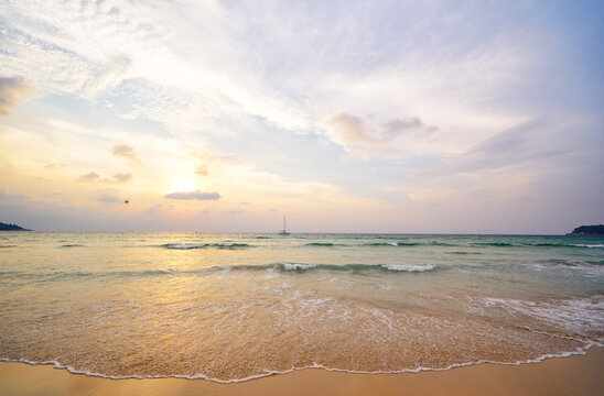 Serene Tropical Beach at Sunset with Calm Waves and Stunning Sky