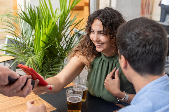 Woman Paying the Bill with Smartphone at a Restaurant