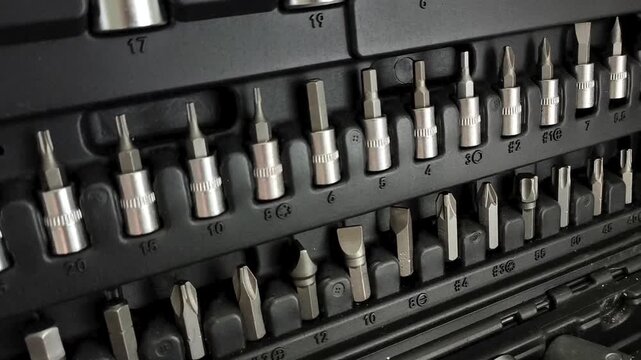 Close up of socket attachments for ratchet wrench in tool case, automotive repair, threaded connections and mechanical work.
