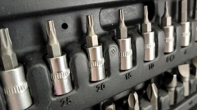 Close up of socket attachments for ratchet wrench in tool case, automotive repair, threaded connections and mechanical work.