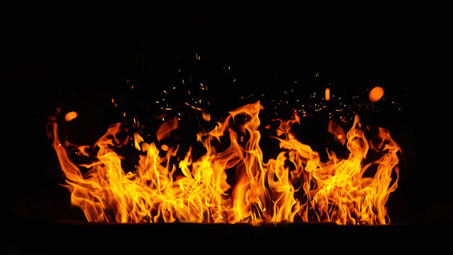 Fire embers particles over black background. Fire sparks background. Abstract dark glitter fire particles lights.