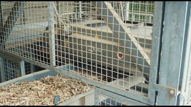 Wood chips in container behind safety fence at biomass plant