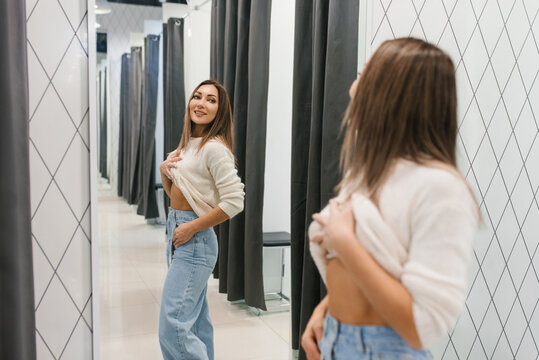 Fitting jeans in shopping mall fitting room