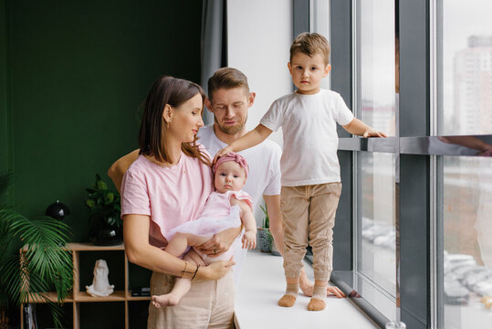 Portrait of Happy Family with Toddler Son and Infant Daughter at Home
