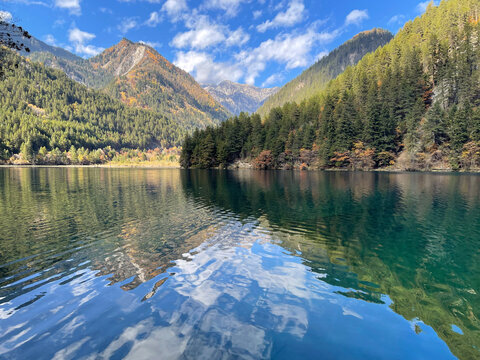 The breathtaking scenery of the crystal-clear turquoise lake with autumn colors at Jiuzhaigou National Park in Sichuan Province, China