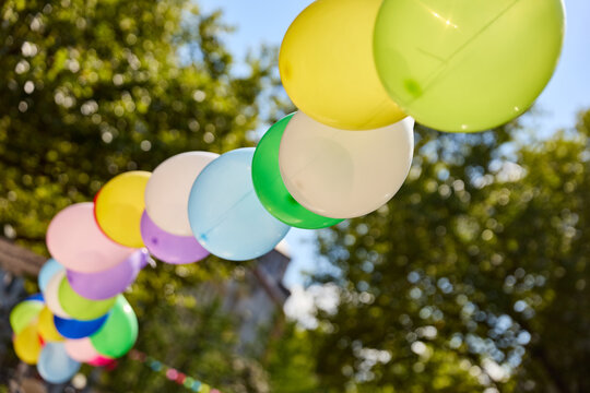 Viele bunte Luftballons als Girlande im Sommer bei Stra&szlig;enfest